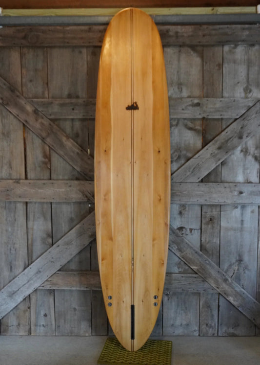 木でできた美しい木製ロングボードのボトム。自然な木目とクラシックなアウトラインが際立つデザイン。