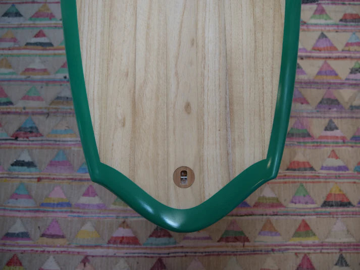 SINE SURFの木製グロベラーサーフボードのテール部分。グリーンレールとラウンドピンテールの形状が際立つディテールショット。