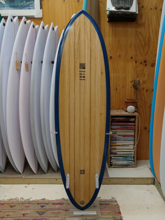 SINE SURF製木製ボードのボトム側。深みのあるネイビーのレールとツインフィン設定が特徴。