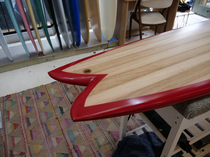 SINE SURF木製ボードのテール詳細。鮮やかな赤のレールと鋭いスワローテールが特徴的。
