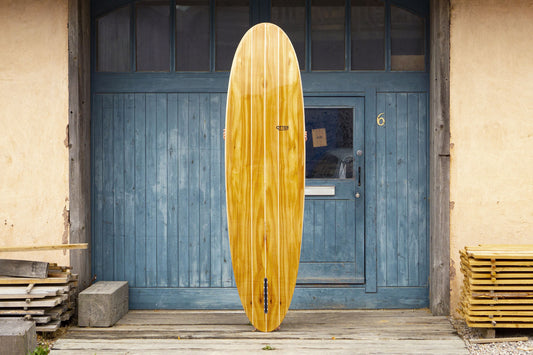 中空構造(ホロー)の木製サーフボード(天然木)の滑らかな表面。深い艶と美しい木目のグラデーション、飾れる・乗れるサステナブルな機能美。