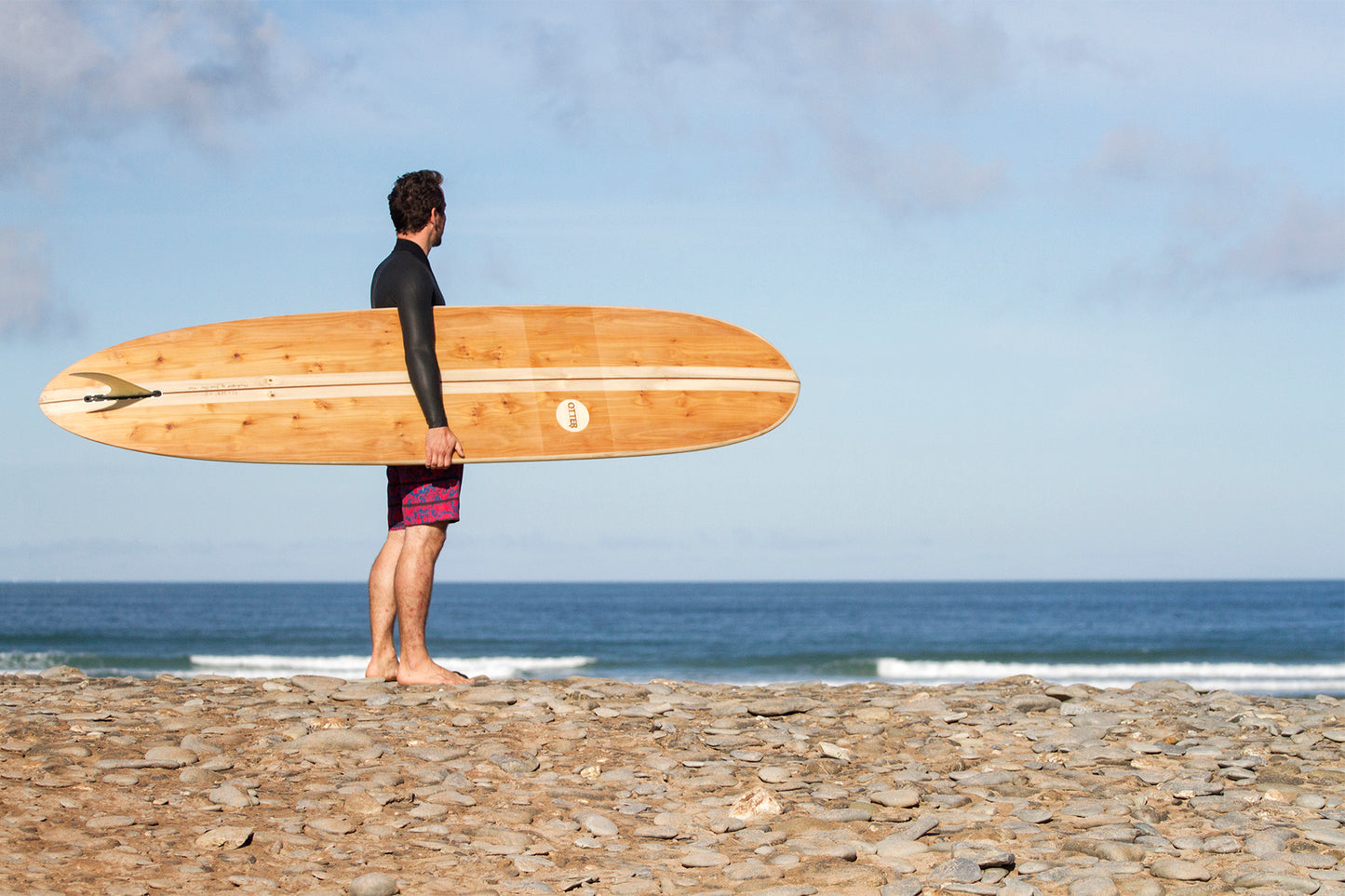 シングルフィンをセットした中空構造(ホロー)の木製サーフボード(天然木)の美しいボトムデザイン。職人の手仕事による丁寧な造りとOtterロゴ、大人のサーフスタイルを格上げする上質なウッドの存在感。