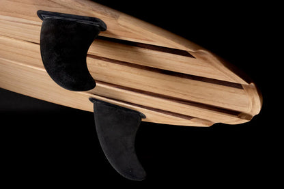 中空構造（ホロー）の木製サーフボード（天然木）のボトム詳細。職人の手仕事が生むチャンネルシェイプとツインフィン、インテリアとして映えるモダンなウッドデザイン。