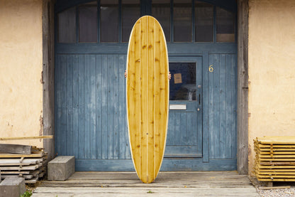 中空構造（ホロー）の木製サーフボード（天然木）を支える職人の手。丁寧な手仕事によって生まれた一点物の存在感、インテリアとしても映える上質なウッドデザイン。