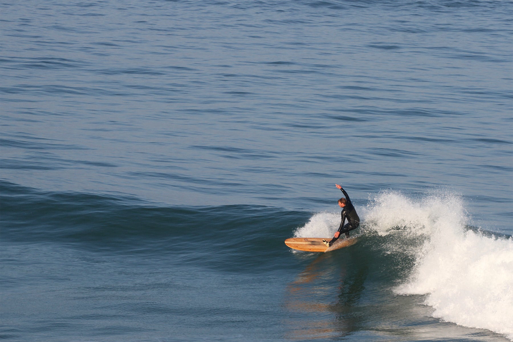 中空構造（ホロー）の木製サーフボード（天然木）と波しぶき。軽量なウッド素材が叶える軽快な操作性、飾れる・乗れるサステナブルな機能美。