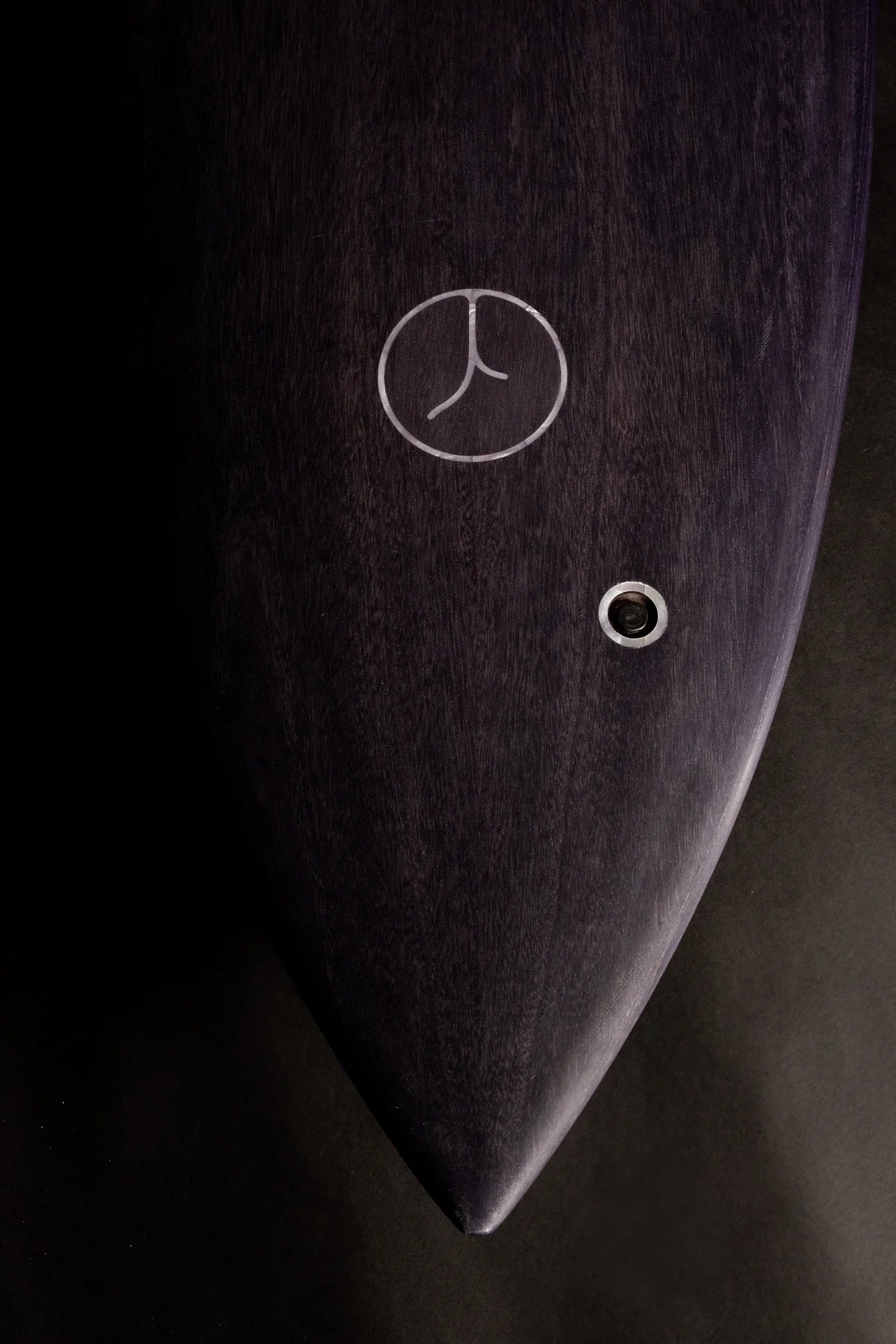 中空構造（ホロー）の木製サーフボード（天然木）のダークウッド仕上げとロゴインレイ。シックな色合いと職人技が光る、洗練されたエコラグジュアリーなデザイン。