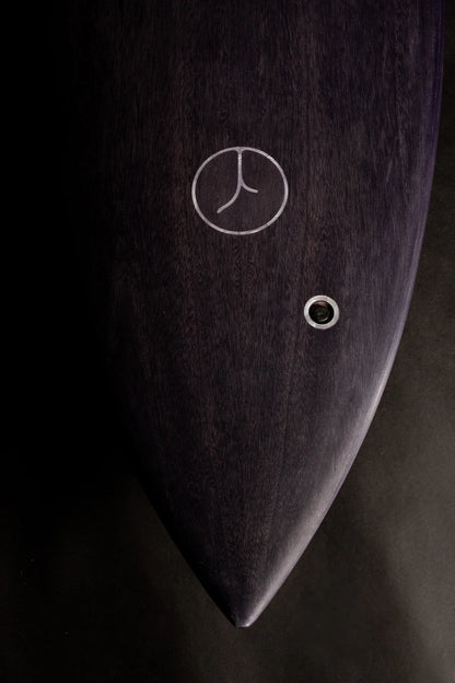 中空構造（ホロー）の木製サーフボード（天然木）のダークウッド仕上げとロゴインレイ。シックな色合いと職人技が光る、洗練されたエコラグジュアリーなデザイン。