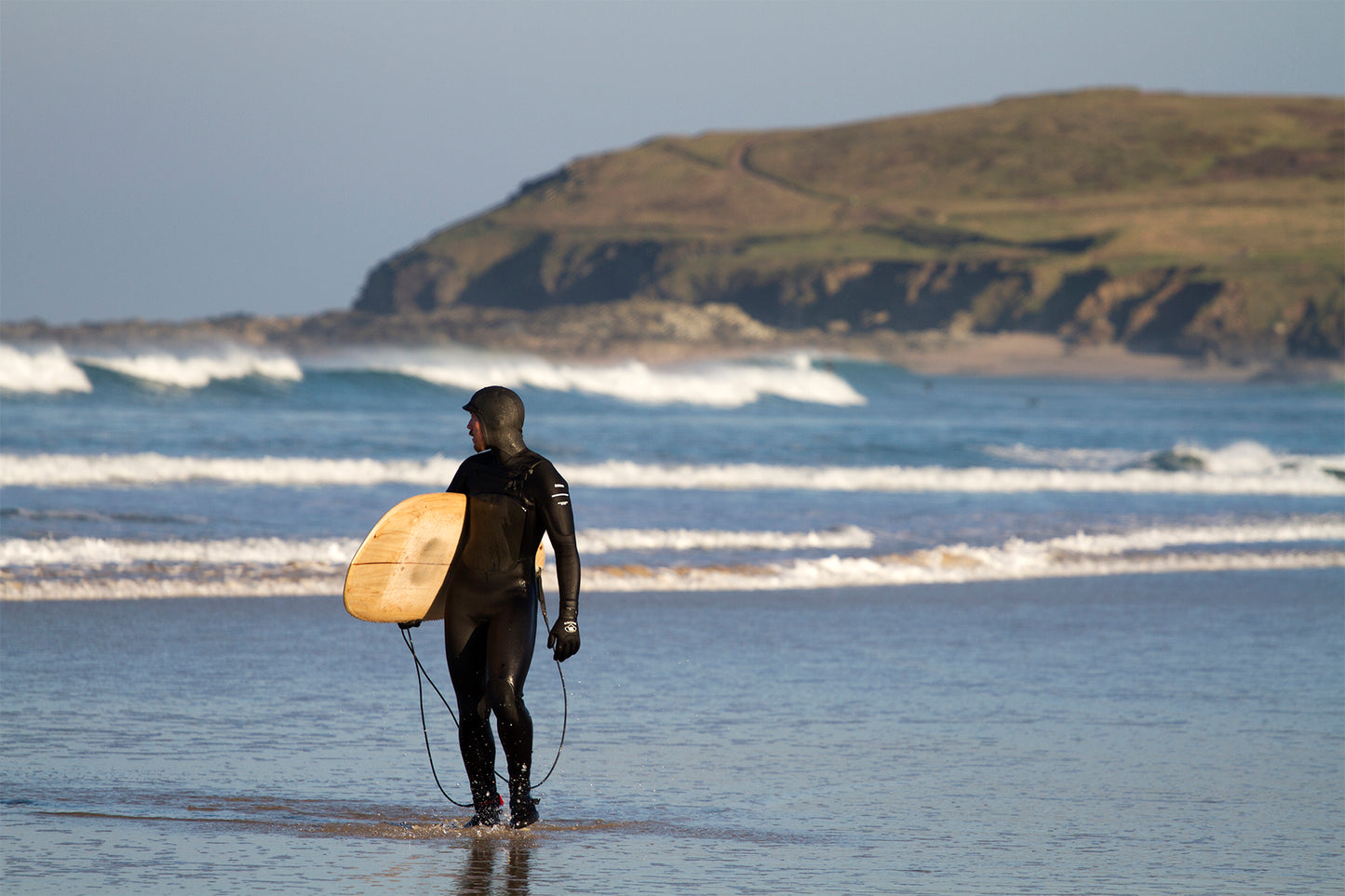 中空構造（ホロー）の木製サーフボード（天然木）と、冷たい海水に濡れたウェットスーツの質感。過酷な冬の環境でも損なわれない美しさ、飾れる・乗れるサステナブルな機能美。