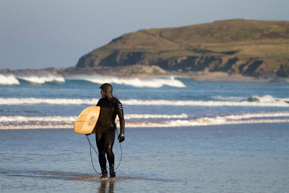中空構造（ホロー）の木製サーフボード（天然木）と、冷たい海水に濡れたウェットスーツの質感。過酷な冬の環境でも損なわれない美しさ、飾れる・乗れるサステナブルな機能美。