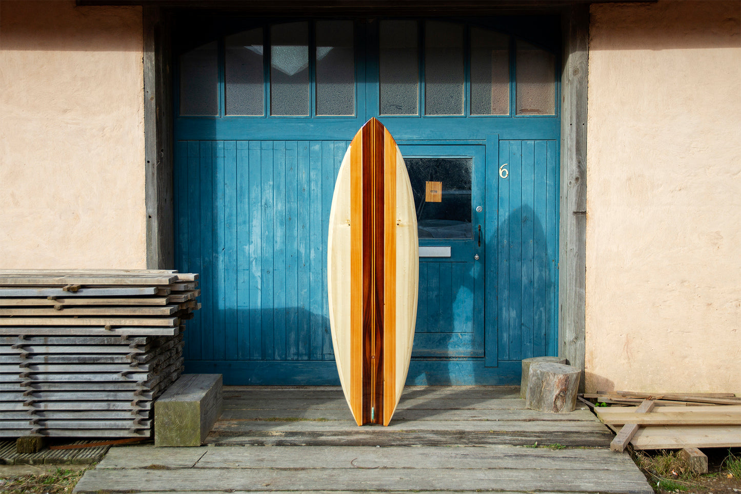 異なる色調の木材を組み合わせ、一本の美しいラインとして統合する技術。スワローテールの先端まで完璧に計算された木組みと、シンメトリーなデザインは、中空構造（ホロー）の木製サーフボード（天然木）における芸術的な上質のクラフトマンシップを体現している。