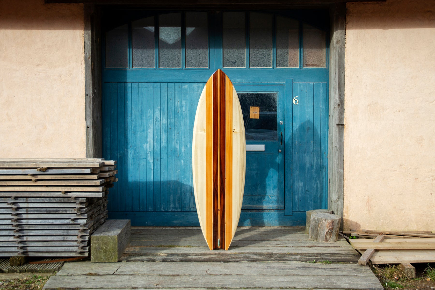 異なる色調の木材を組み合わせ、一本の美しいラインとして統合する技術。スワローテールの先端まで完璧に計算された木組みと、シンメトリーなデザインは、中空構造（ホロー）の木製サーフボード（天然木）における芸術的な上質のクラフトマンシップを体現している。