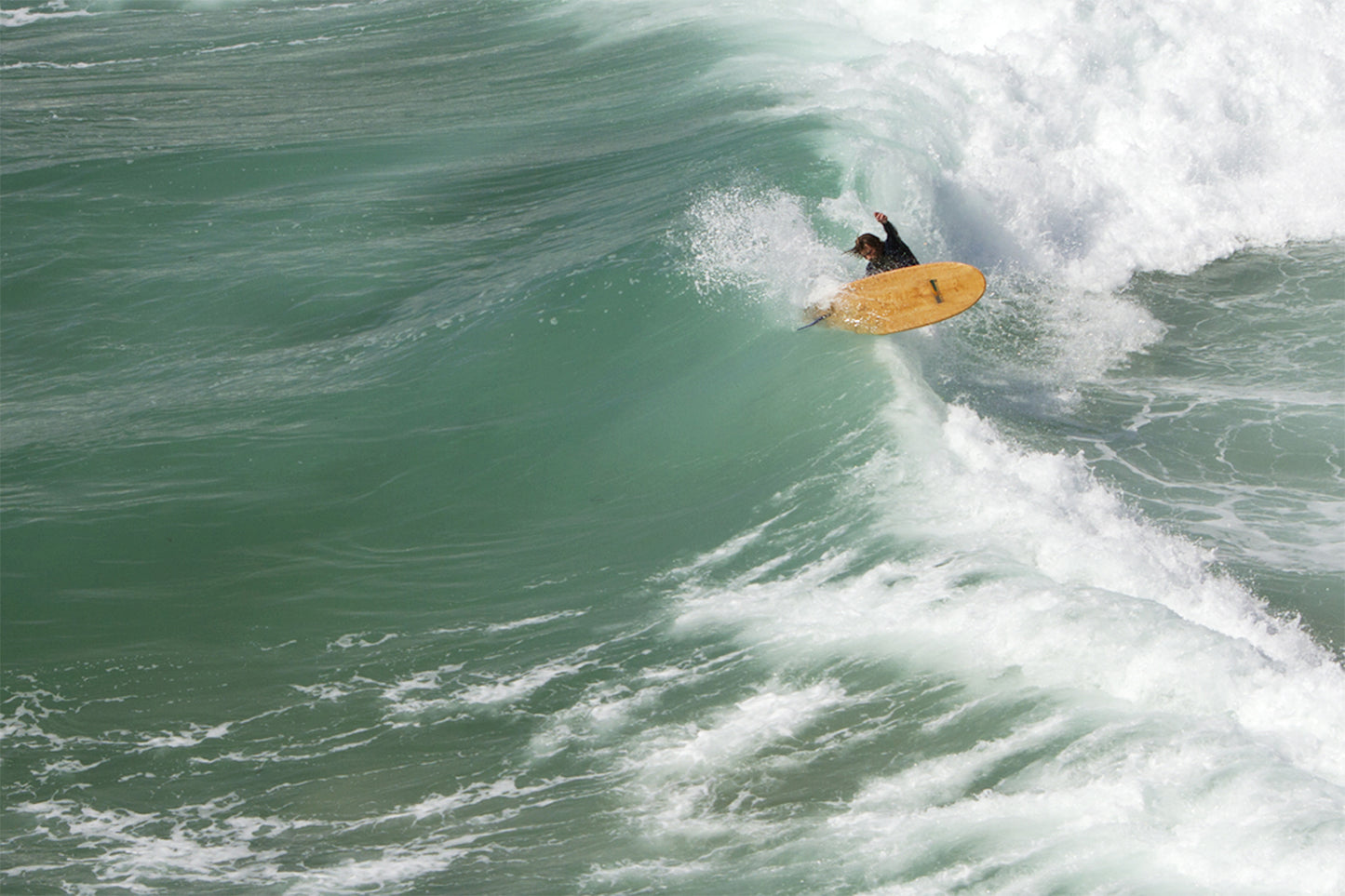 ダイナミックなスプレーを上げて波を切り裂く、迫真のライディング。中空構造（ホロー）の木製サーフボード（天然木）と共に波のパワーをコントロールする、エキサイティングで躍動感あふれる大人のサーフシーン。