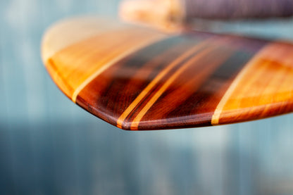 飴色に輝くシダー（杉）やポプラなどの木材が織りなす、深みのあるグラデーション。ガラスのように滑らかなレジンコーティングの下に透ける緻密な木目が、飾れる・乗れるサステナブルな機能美と、天然素材だけが持つ温かな質感を伝えている。