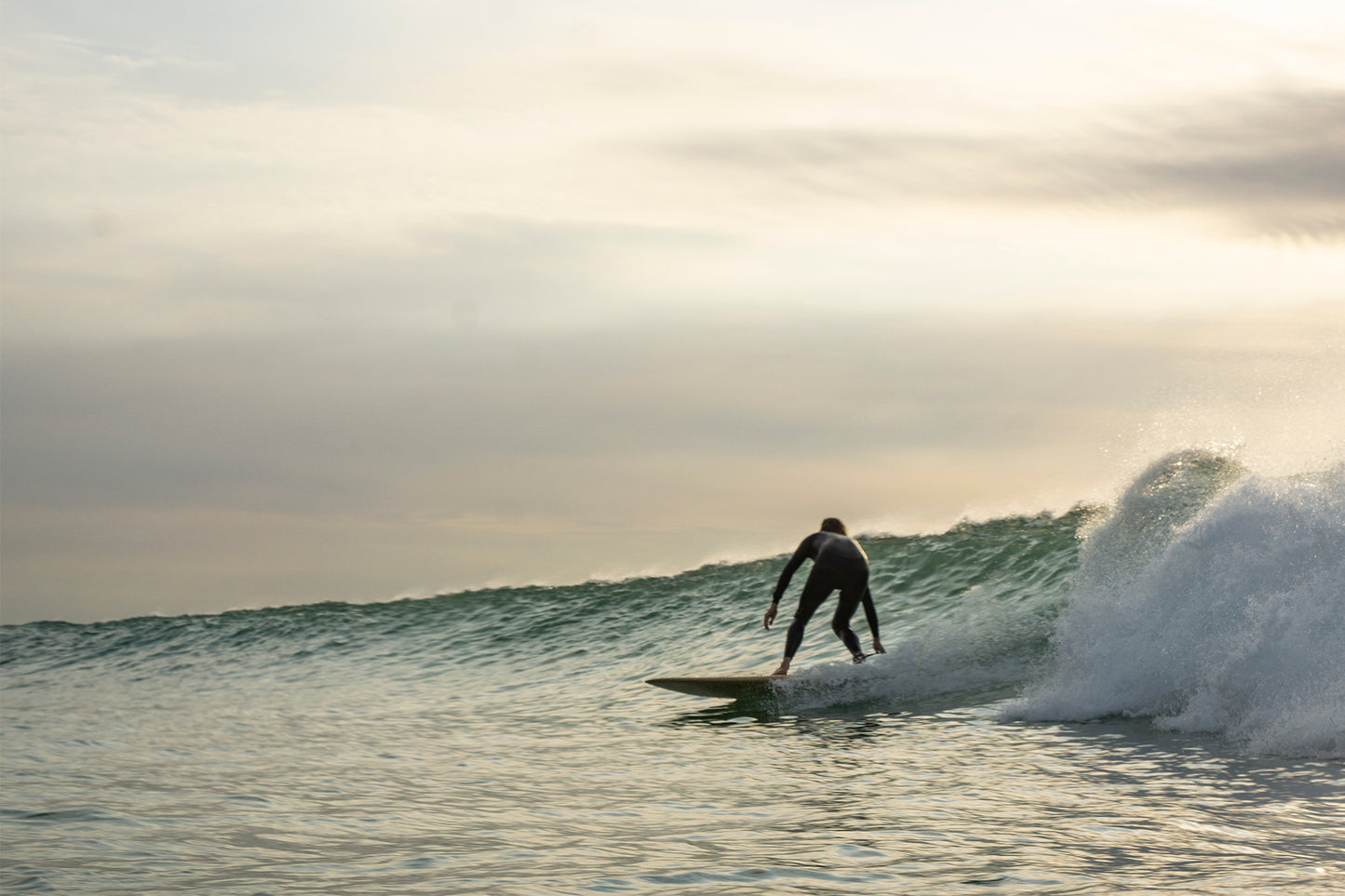 サンセットタイムのグラッシーな波で、中空構造（ホロー）の木製サーフボード（天然木）をトリミング。一日の終わりを締めくくる至福のライディングと、心に残る美しい光景。