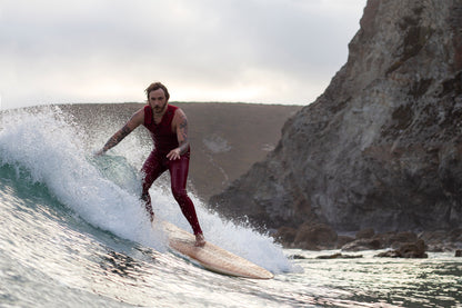 クリフサイドのブレイクを舞台に、中空構造（ホロー）の木製サーフボード（天然木）で優雅にトリミング。ヴィンテージライクな装いとクラシックなボードが融合した、スタイル溢れる大人のサーフシーン。