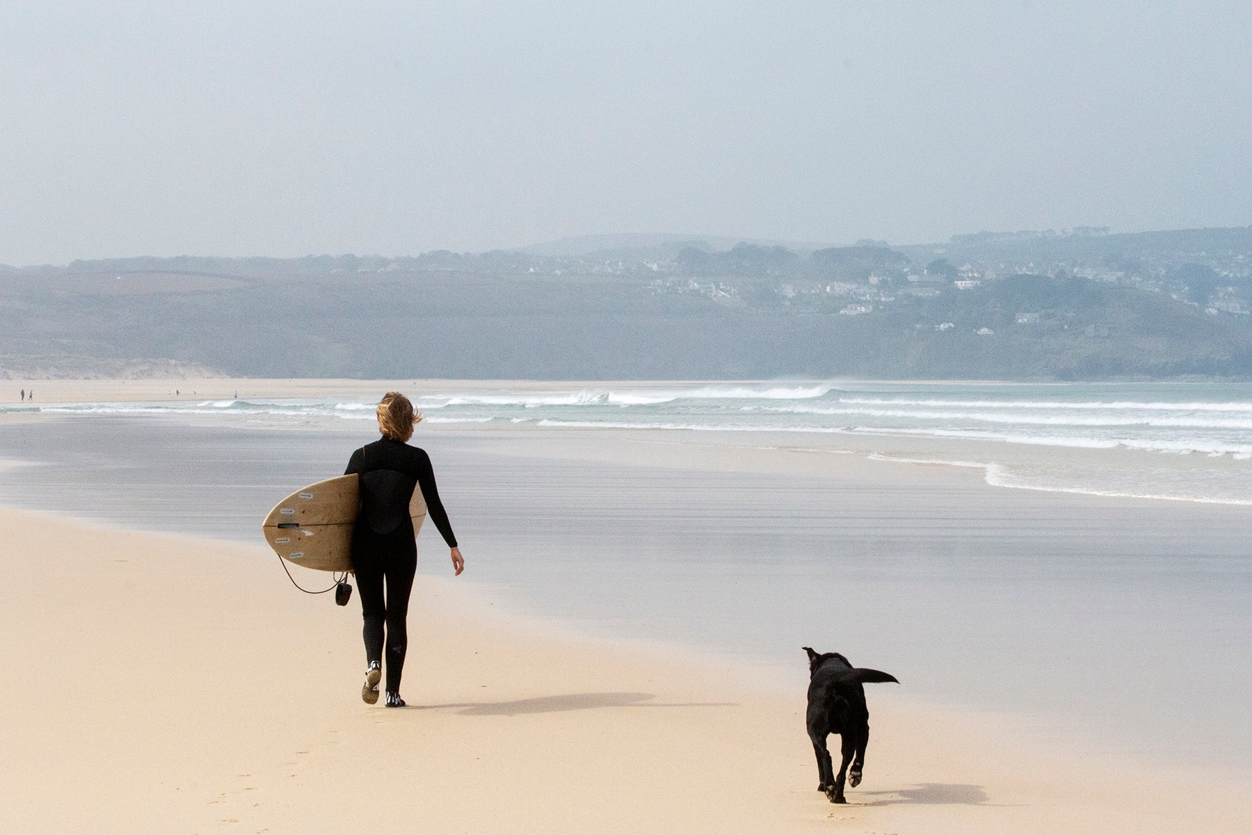 オフショアに整えられた小波のラインを見つめ、中空構造（ホロー）の木製サーフボード（天然木）と共にビーチを歩く。愛犬とシェアするメローな朝のセッション、心身をリセットする贅沢な週末。